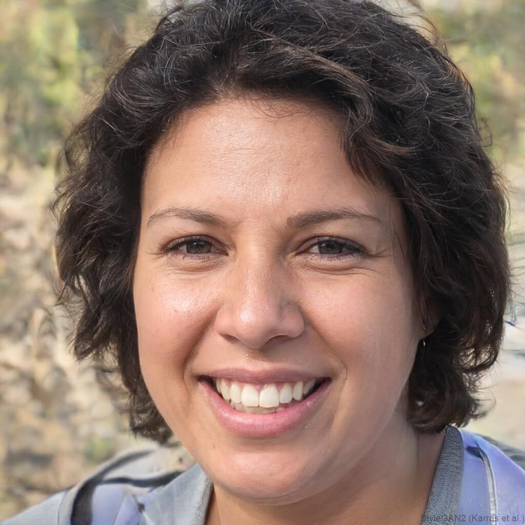 Brown woman with dark hair and brown eyes smiling